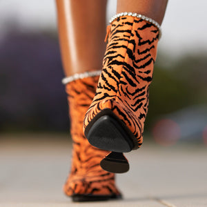 woman wearing tiger-striped boots with a shoe gummi applied to the bottom